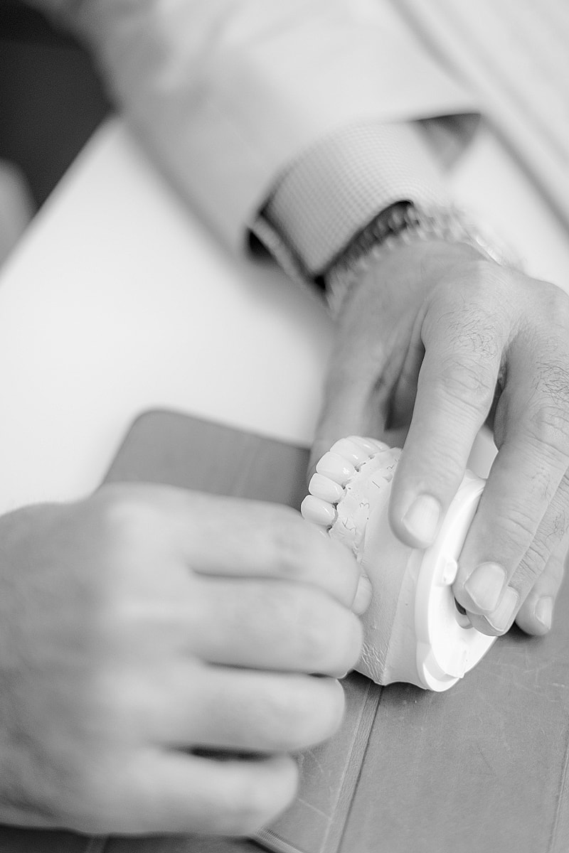 Hands holding dental model on notebook.