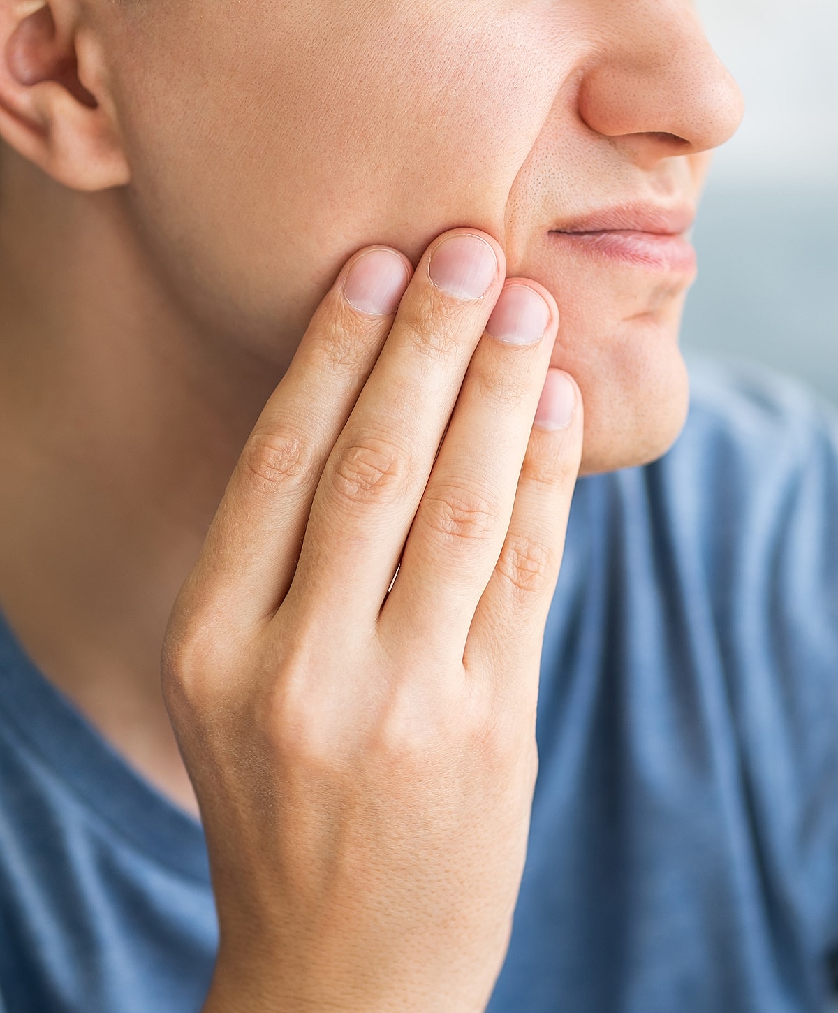 Person touching their face in contemplation.