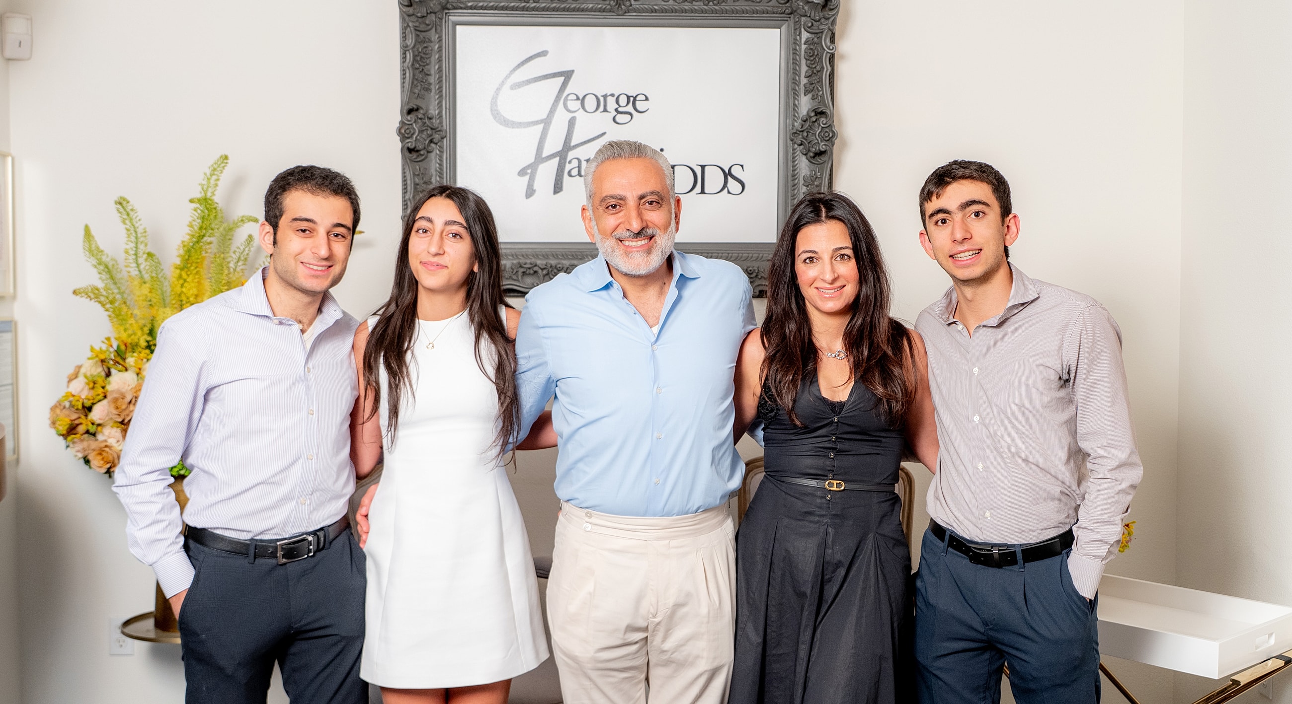 Family portrait in front of a George Haritodu's sign.
