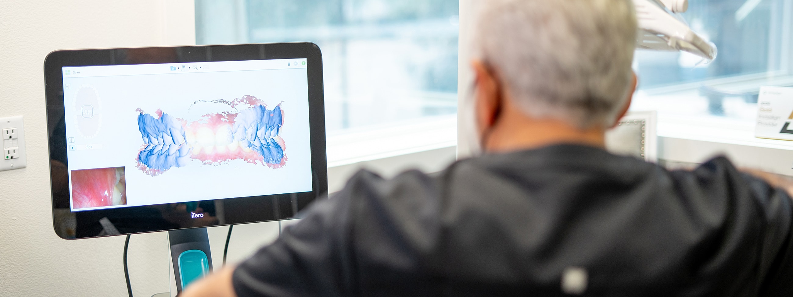Dentist using digital imaging for patient assessment.