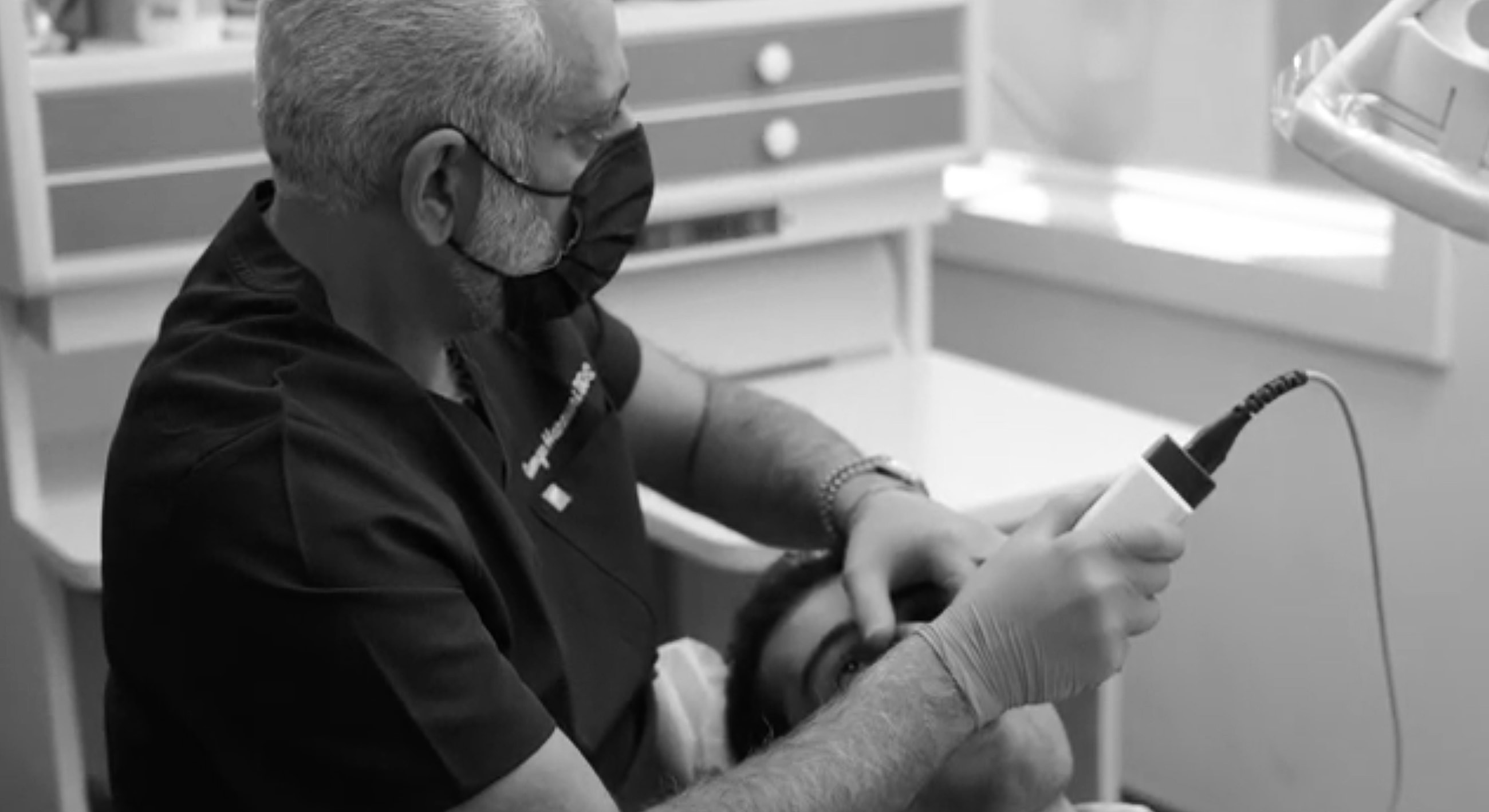 Dentist examining patient with medical equipment.