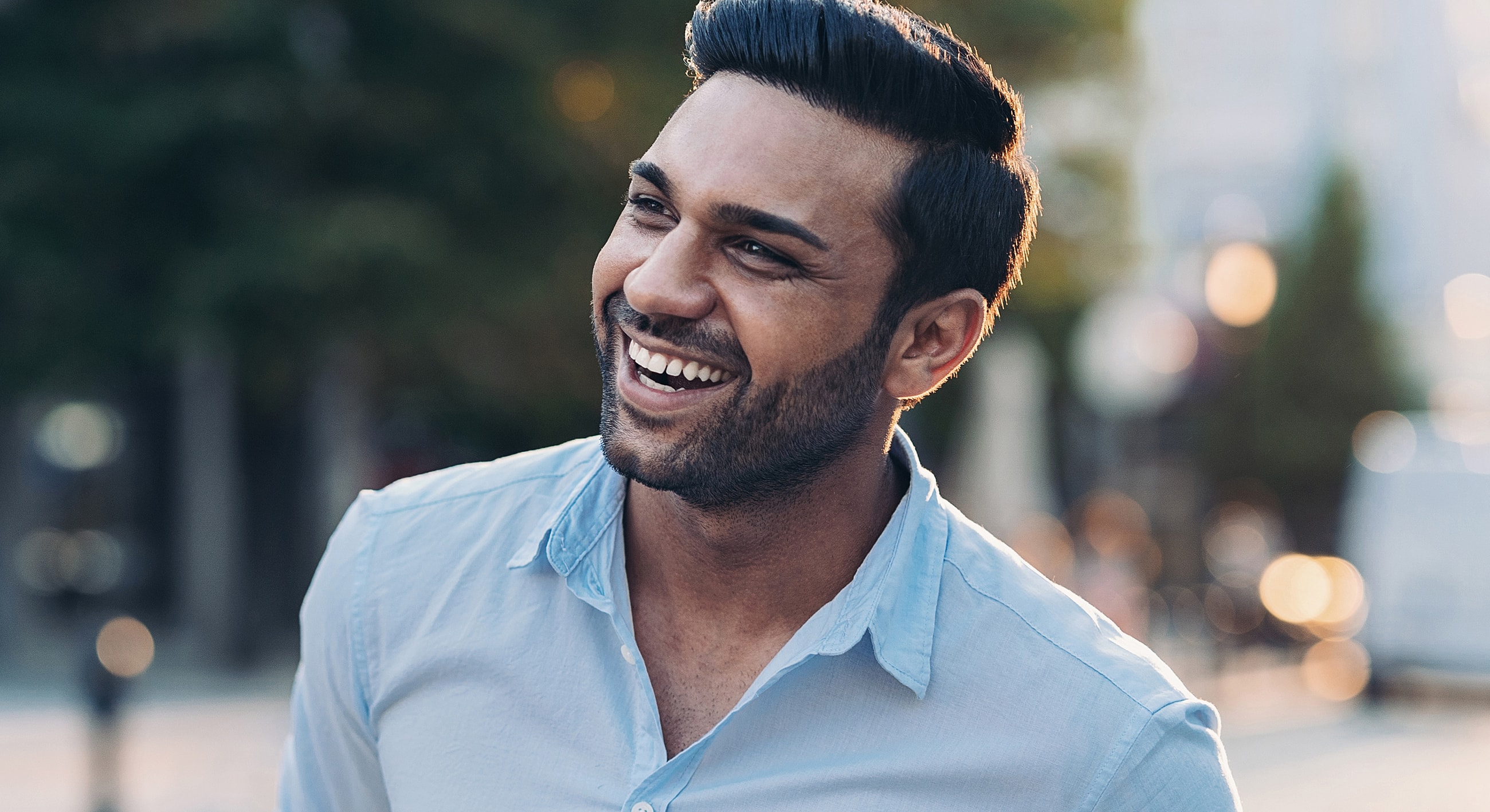 Smiling man enjoying a sunny day outdoors.
